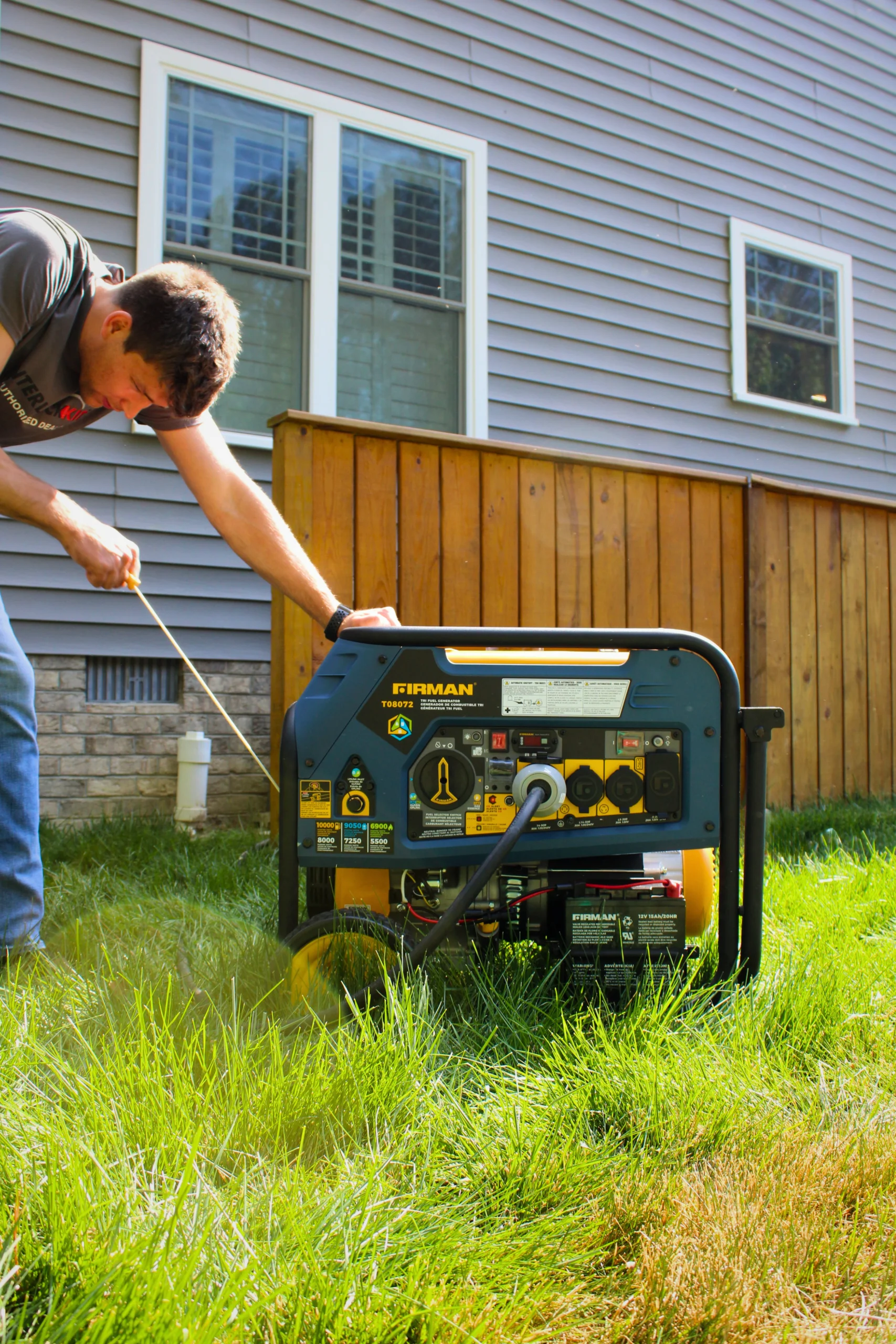 Man pulling the recoil starter on a Firman portable generator in a backyard