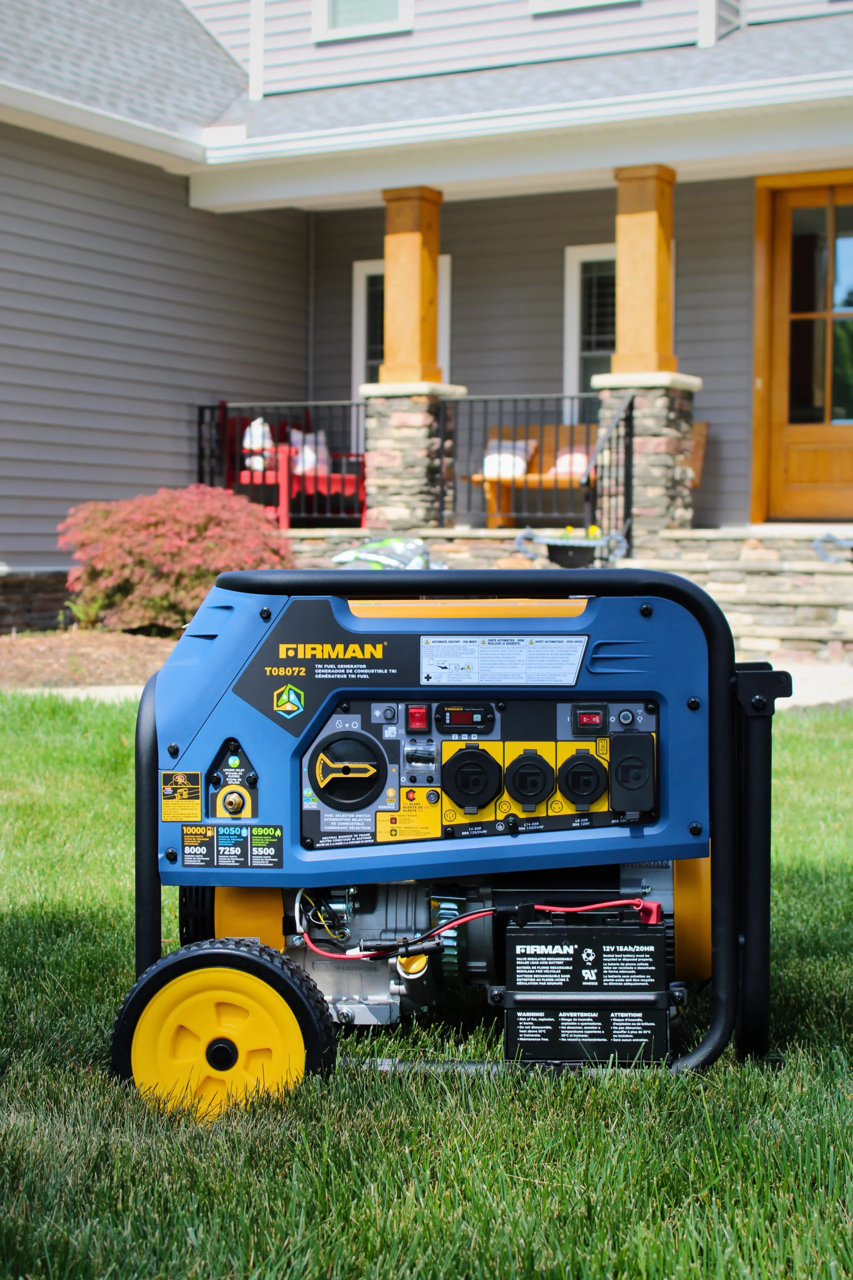 Firman T08072 Tri-Fuel Generator Outside Residential Home Firman T08072 tri-fuel portable generator sitting on a lawn in front of a house