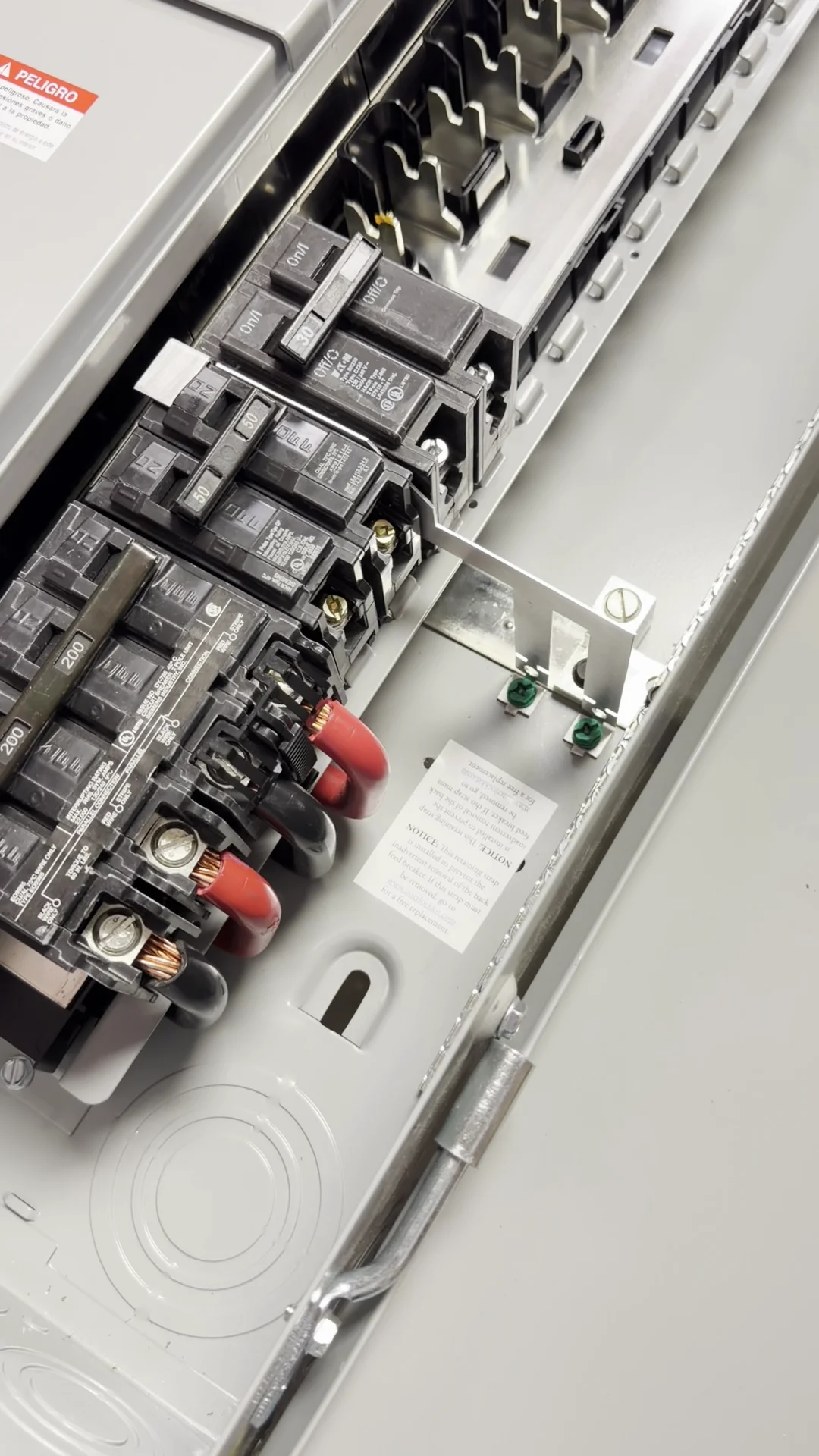 Photo of Interlockkit's adjustable single column breaker retainer securing a generator breaker in an electrical panel