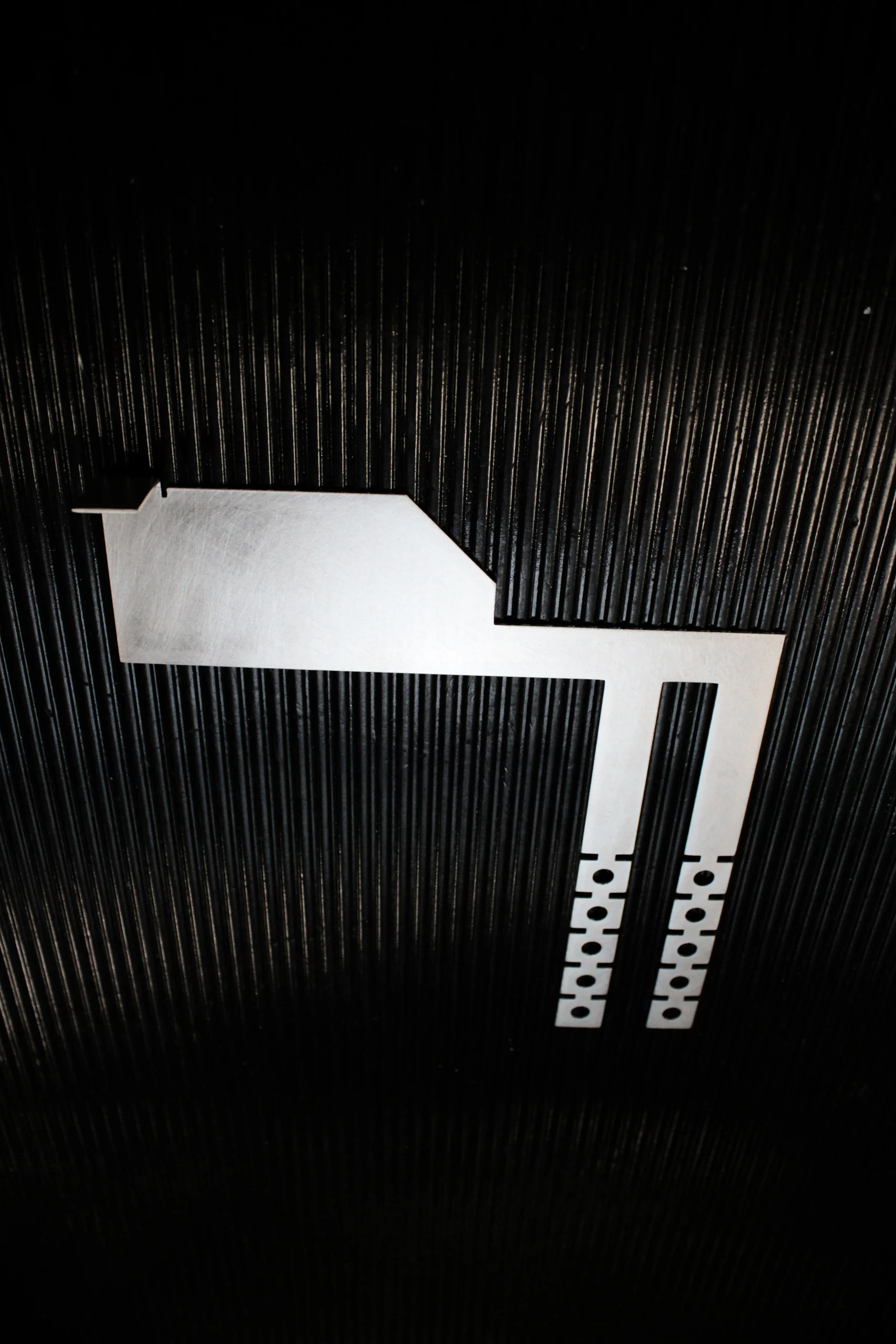 Photo of the Interlockkit adjustable single column breaker retainer on a black background