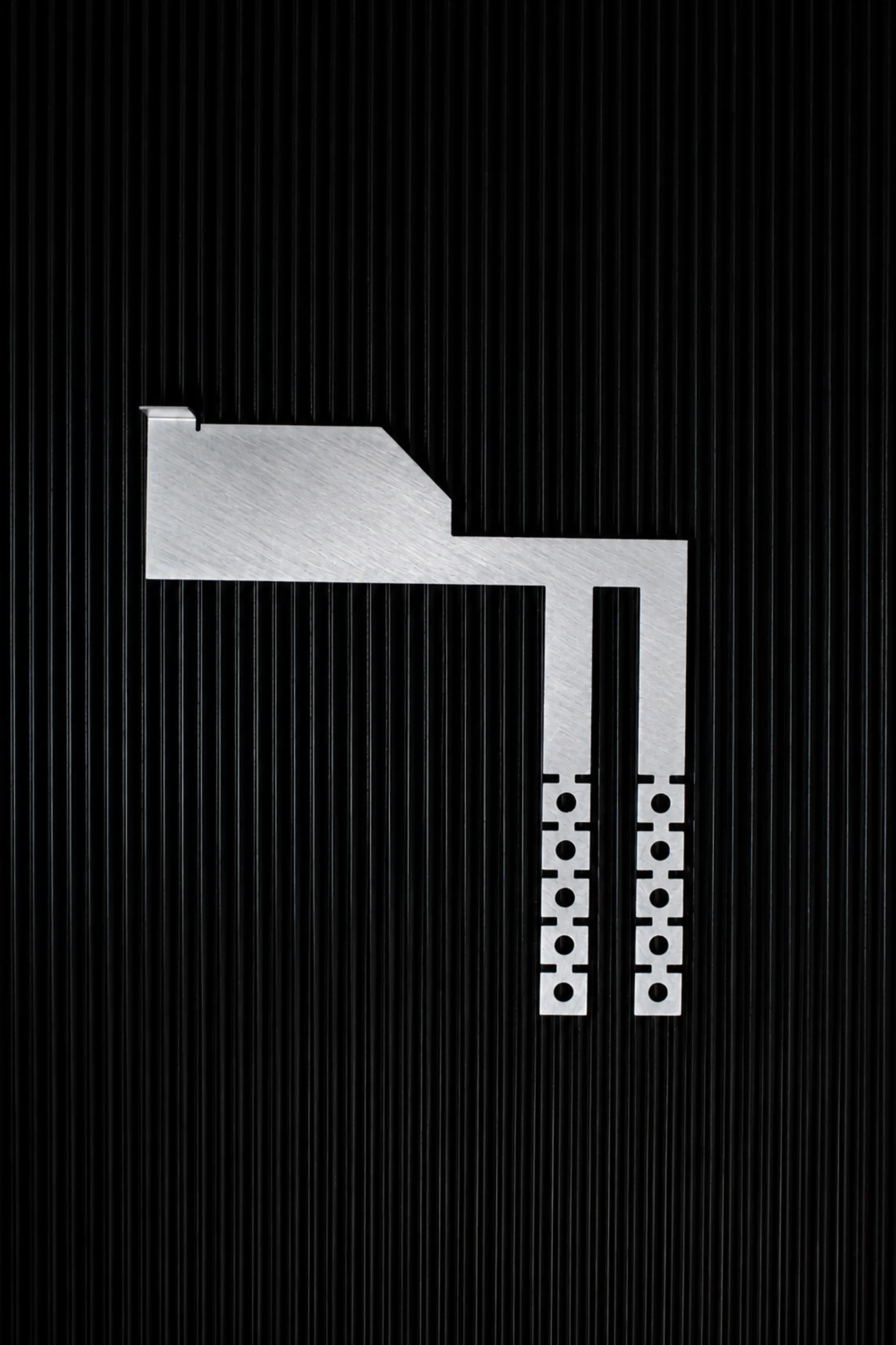 Photo of the Interlockkit adjustable single column breaker retainer on a black background