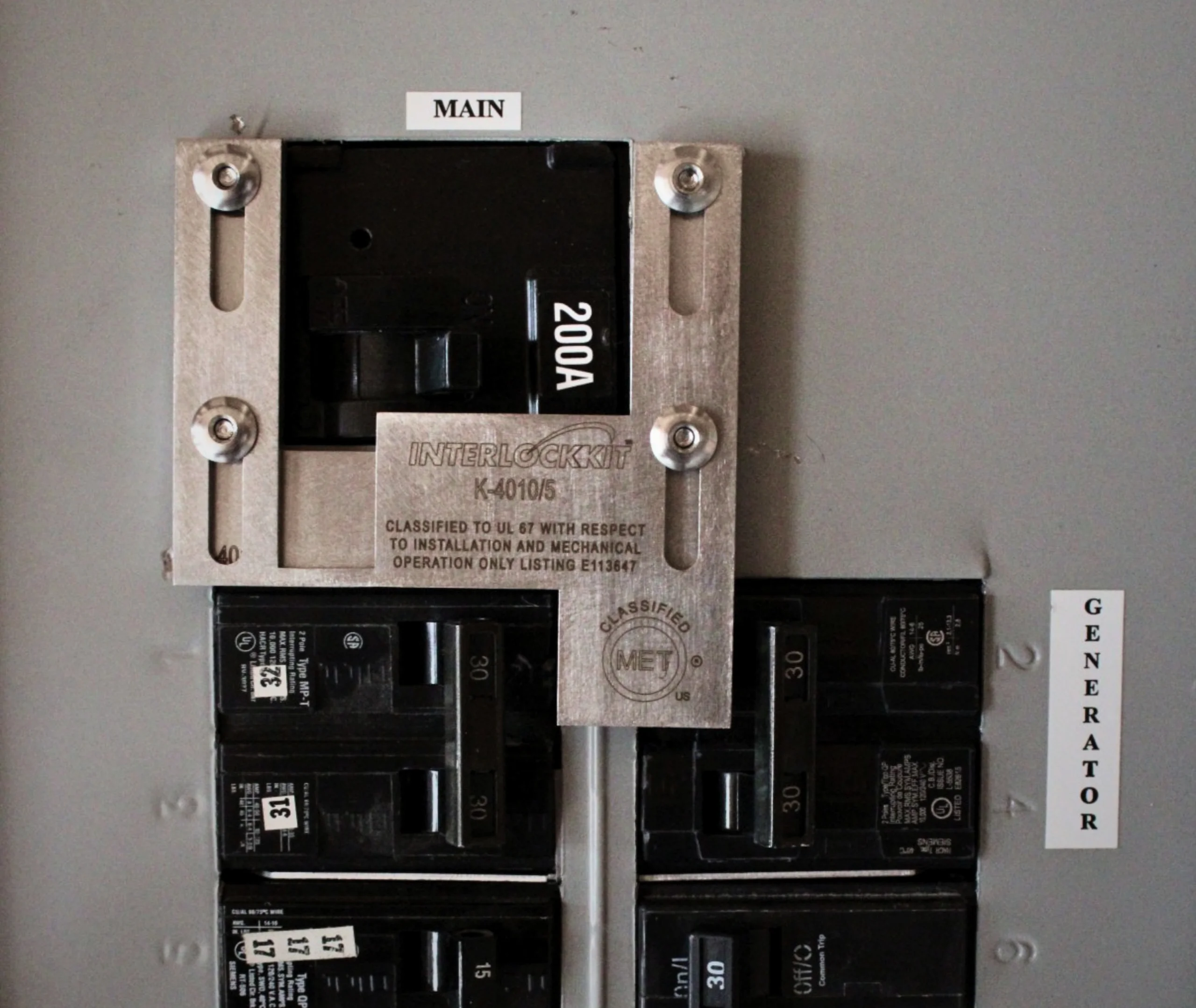 Interlockkit K-4010/5 Generator Interlock Kit Installed on a 200A Panel Interlockkit K-4010/5 generator interlock kit installed on a 200A residential electrical panel with main and generator breakers labeled